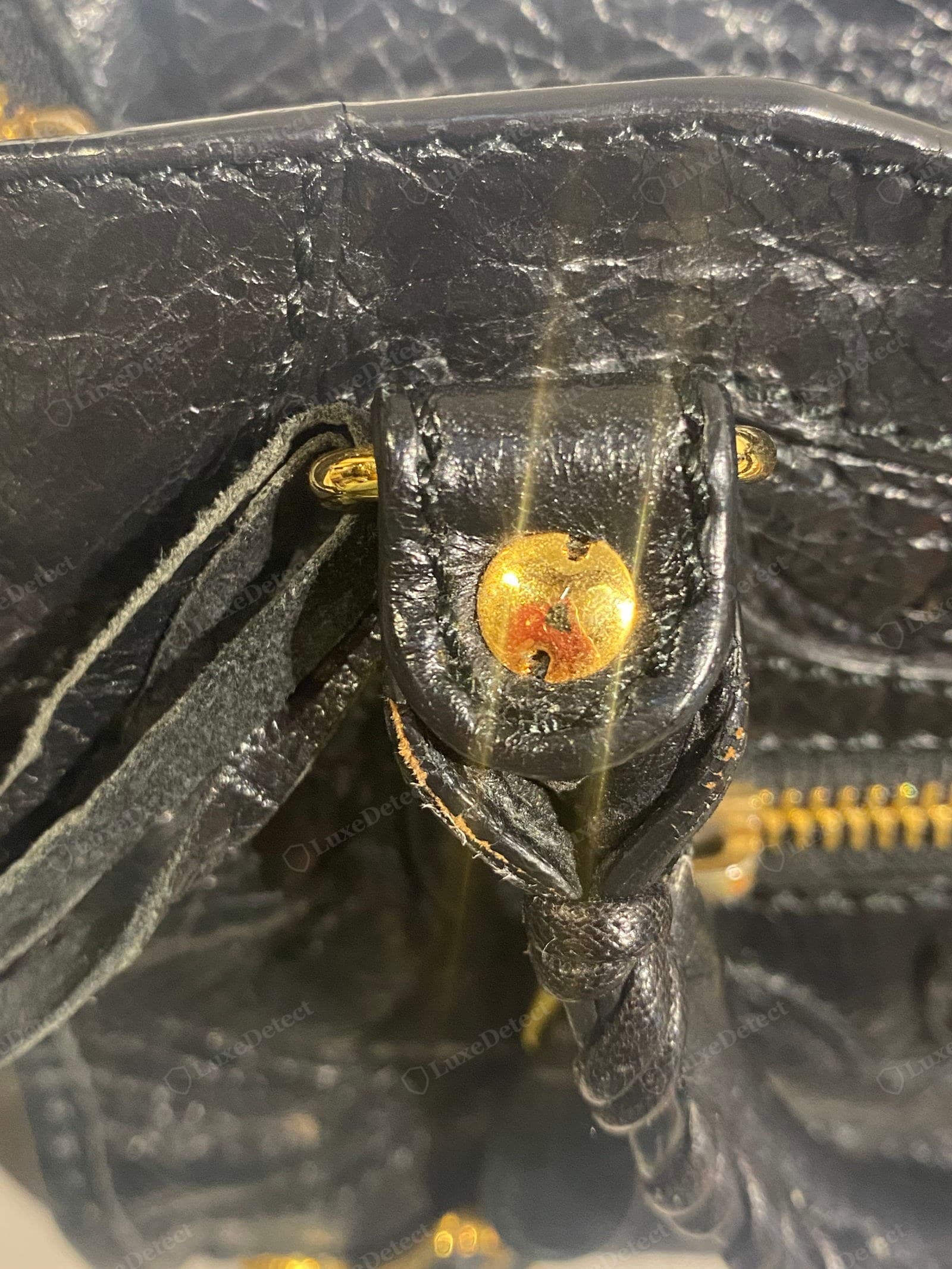 Counterfeit Balenciaga City leather — tan leather with an over-glossy sheen and a coarser, more uniform "crinkle", the giant studs textured with a crosshatch mesh instead of a smooth dome, and a bright shiny zip
