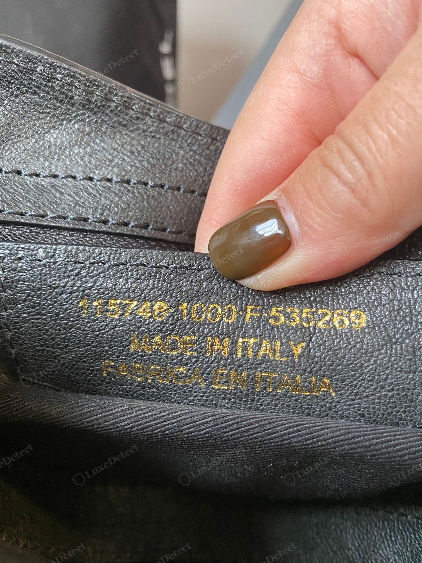 Counterfeit Balenciaga City tag — the style number, "MADE IN ITALY" and "FABRICA EN ITALIA" printed in gold ink directly on a leather lining panel; genuine tabs are blind-embossed with no ink
