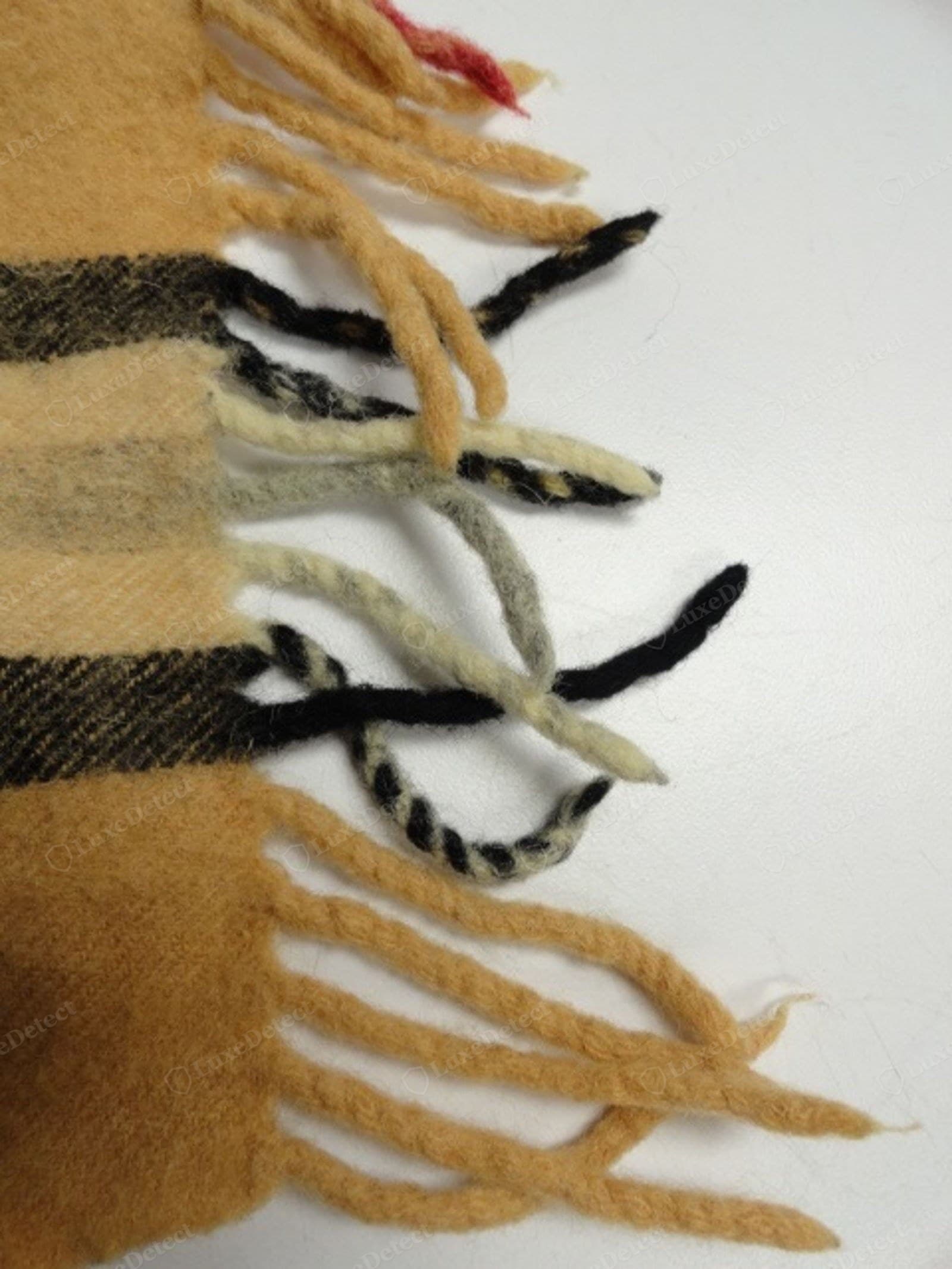 Counterfeit Burberry scarf fringe — uneven bundles, serged or glued edge, coarser yarn, fraying