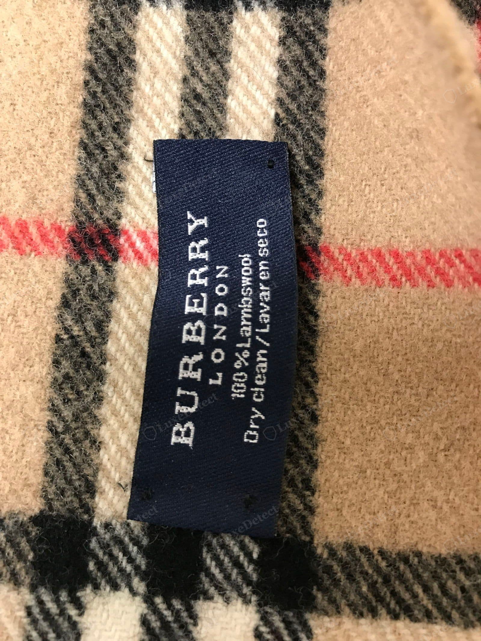 Counterfeit Burberry scarf label — printed or loose weave, fuzzy text, wrong origin, crooked stitching