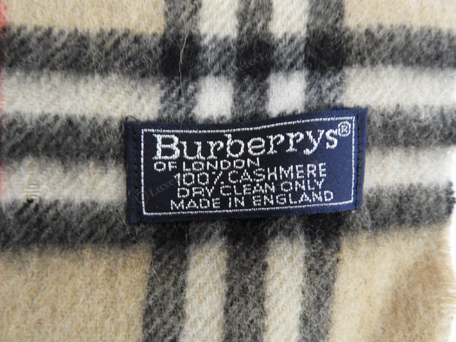 Genuine Burberry scarf label — densely woven, sharp BURBERRY / Made in Scotland, sewn flat and even