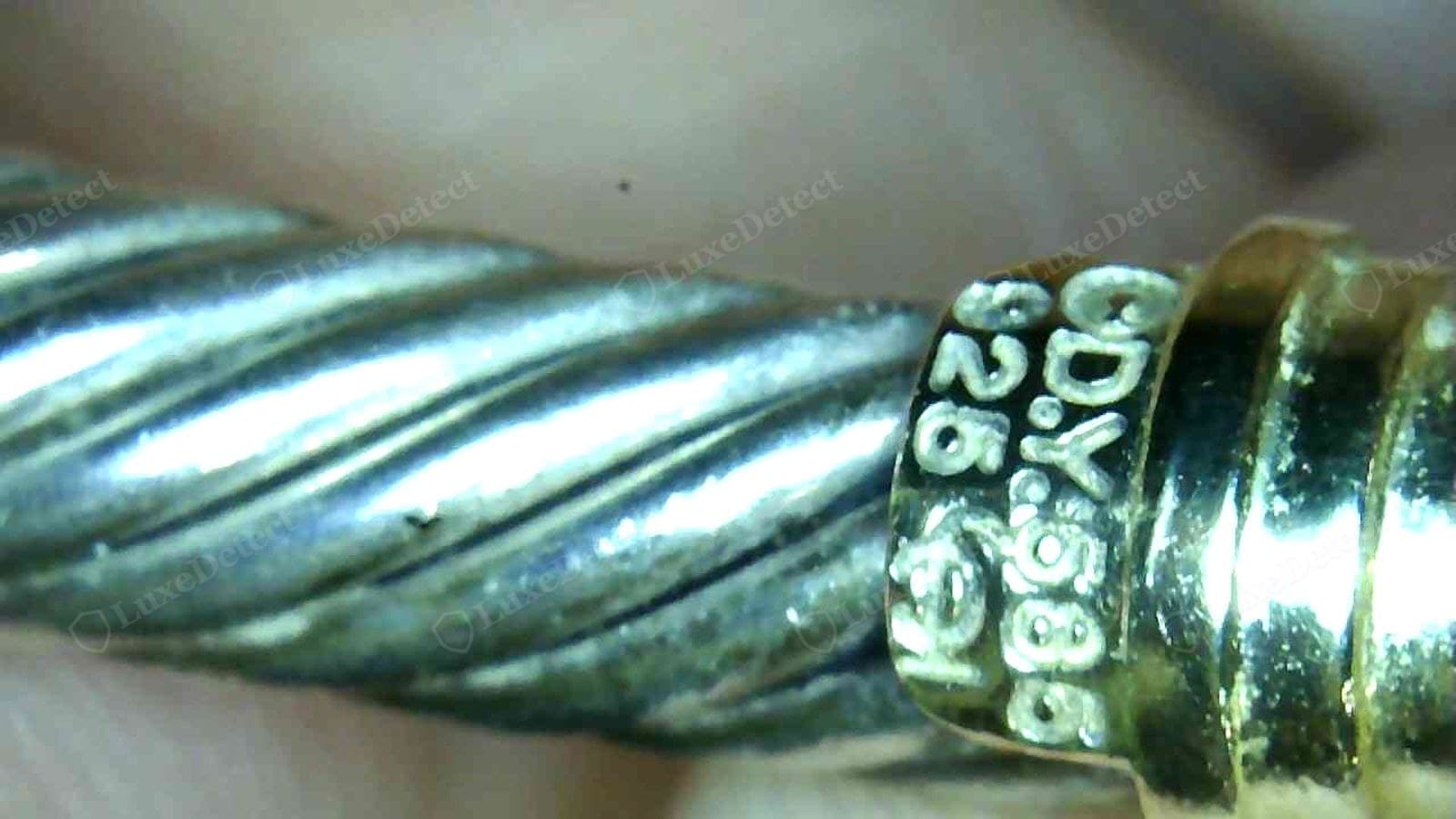 Genuine David Yurman hallmark — "D.Y. 925" and a "585" gold mark cleanly and evenly struck on the end-cap collar, letters sharp and correctly proportioned