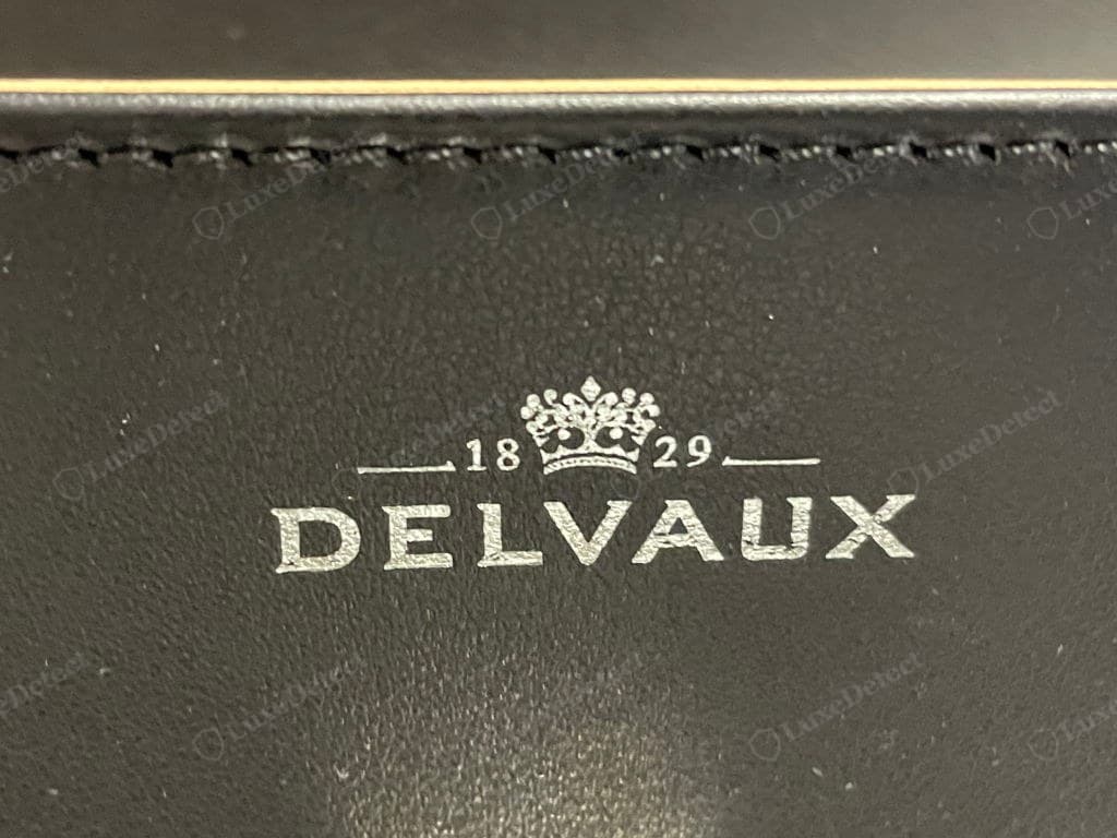 Counterfeit Delvaux stitching and edge — uneven stitch length and tension, shiny thread, thick cracking edge paint that overruns