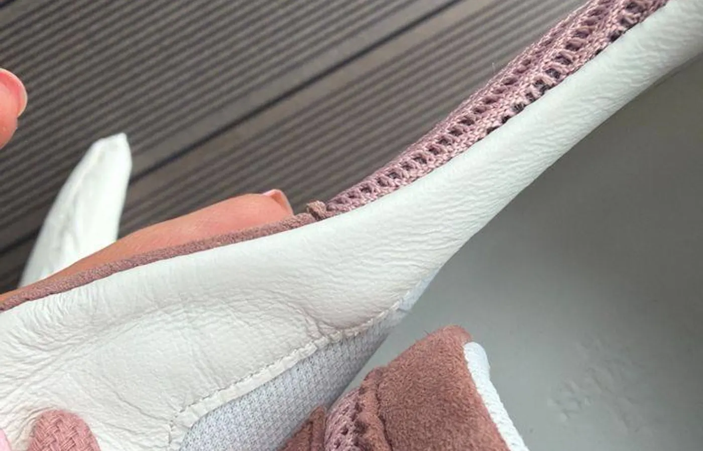 HERMÈS blind-debossed into the suede toe overlay of a rose pair — tonal, legible by the impression rather than by colour contrast