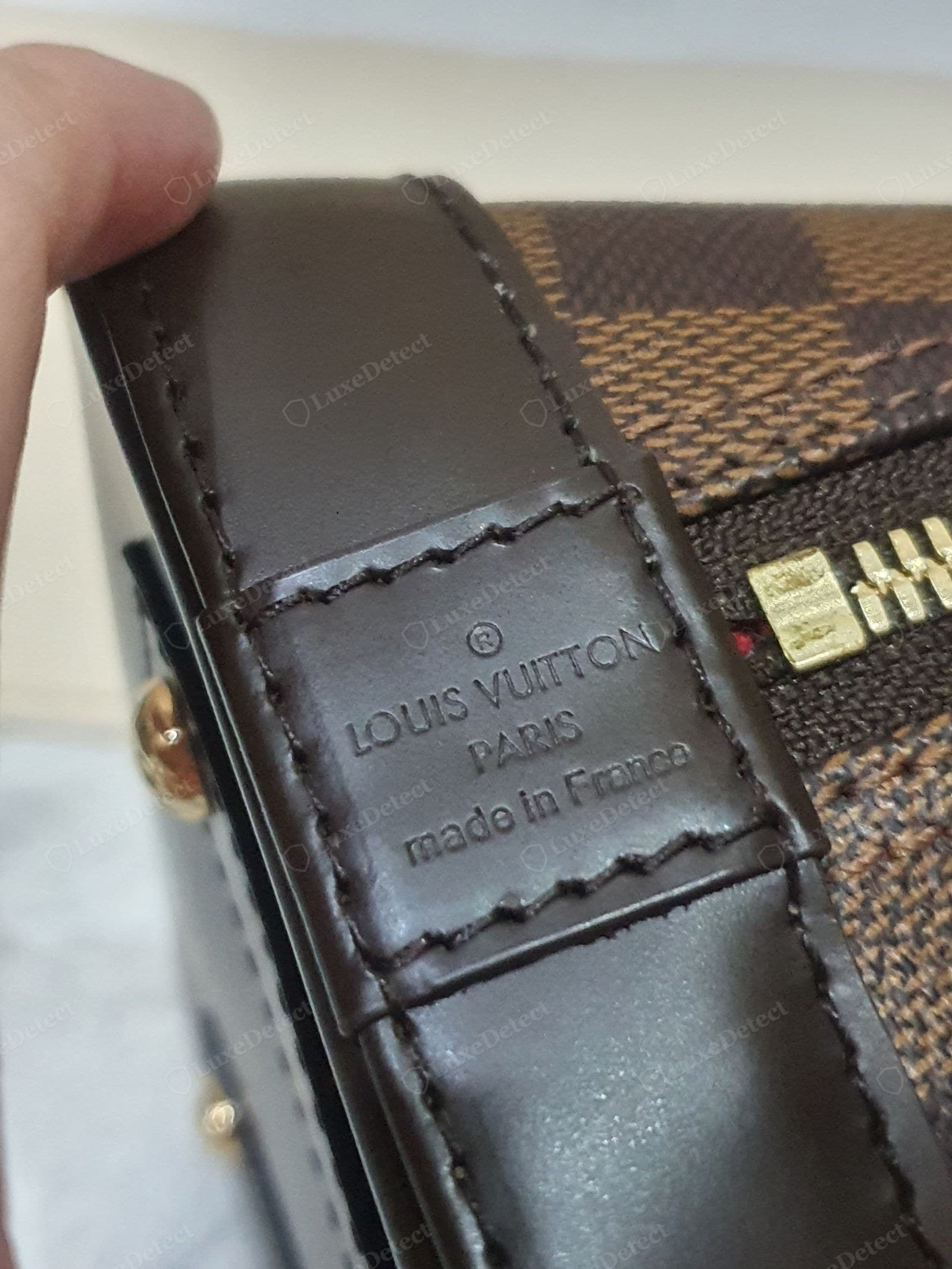 Counterfeit LV Alma — a "made in" line stamped on the exterior of the bag where a genuine Alma carries it only inside
