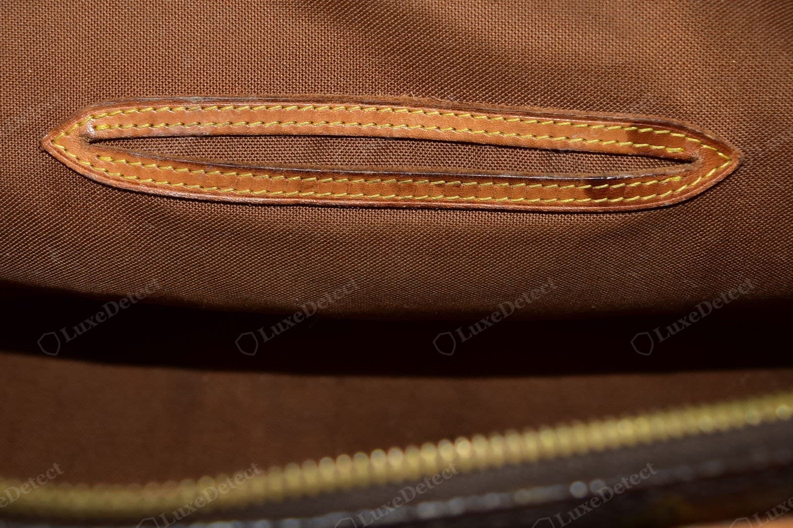 Genuine LV Alma vachetta — a slit-pocket trim inside a Monogram Alma, the leather aged to an even honey with a soft handled sheen, fine tight grain, yellow contrast saddle stitching