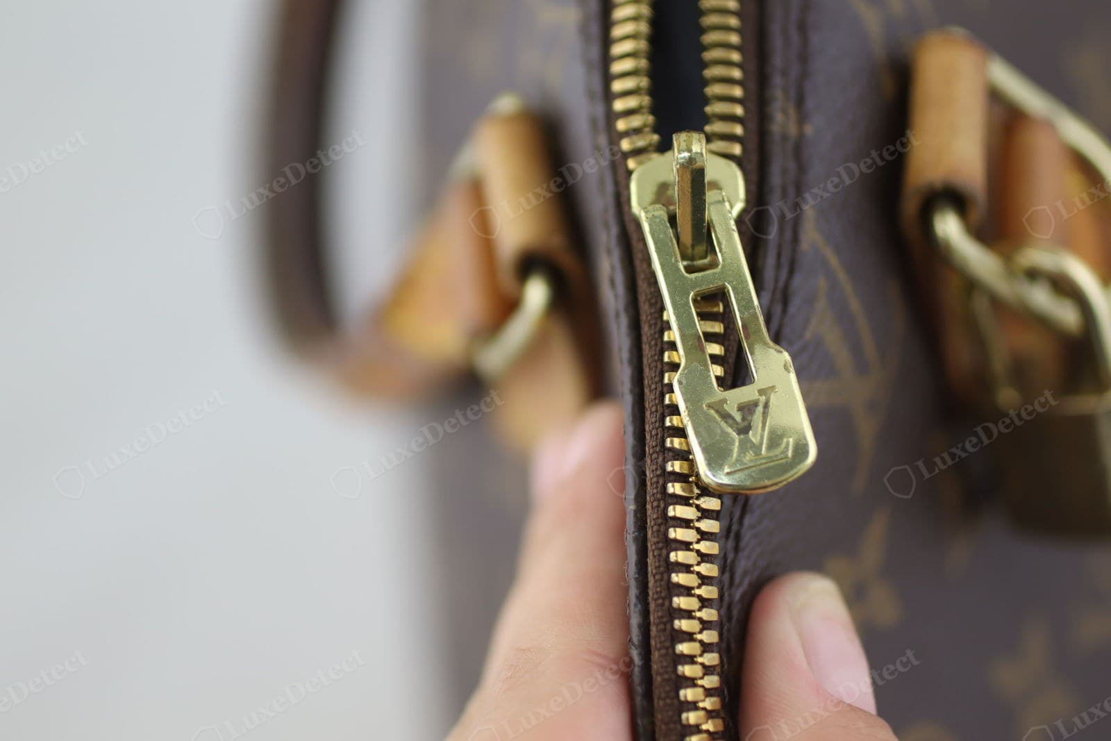 Genuine LV Alma zipper — the pull cleanly stamped "LOUIS VUITTON", the slider smooth, tape matched to the lining