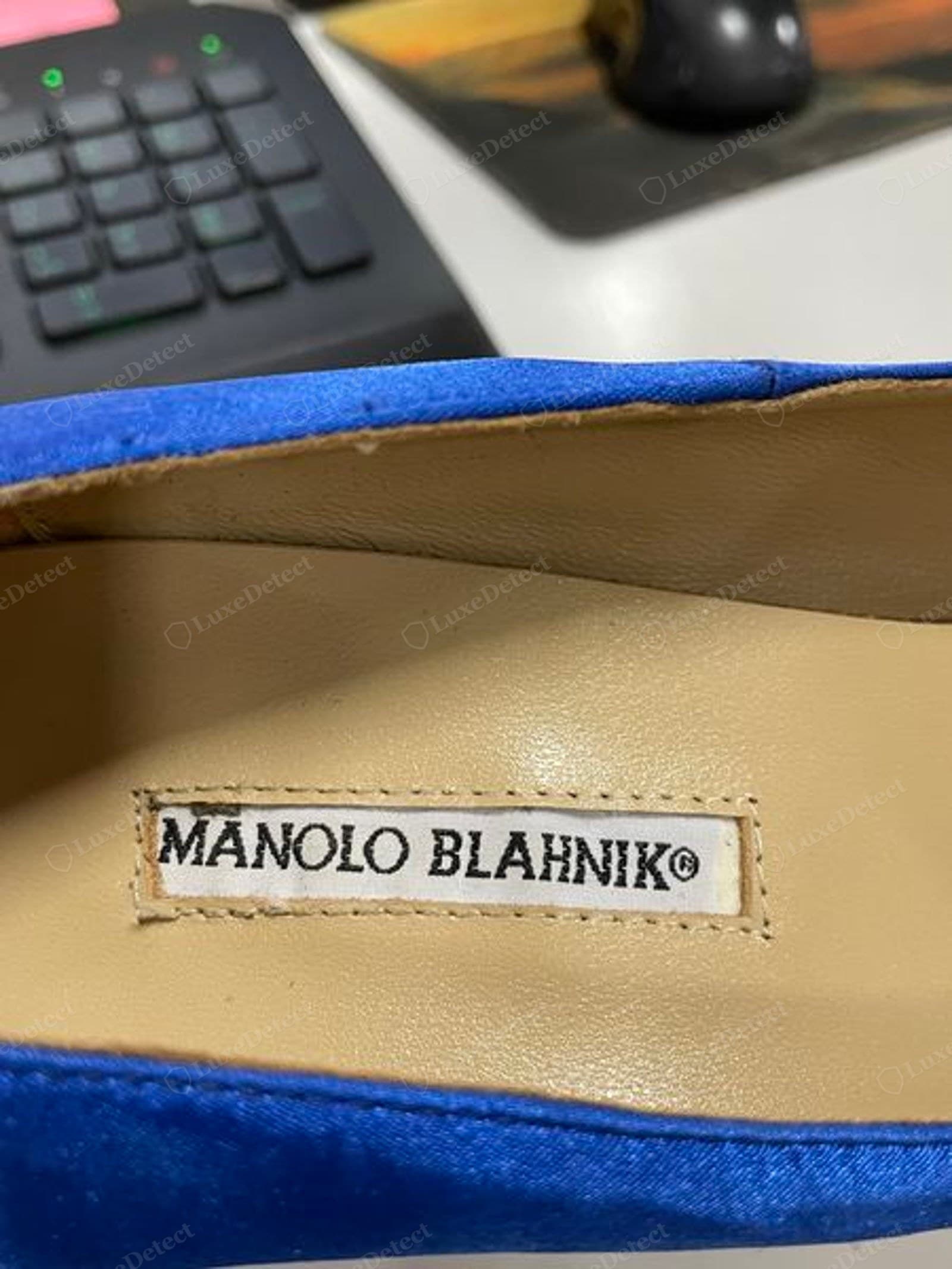 Counterfeit Manolo Blahnik insole — a second fake label reading "MANOLO BLAHNIK©", the letterforms subtly wrong and the label edges fraying and lifting