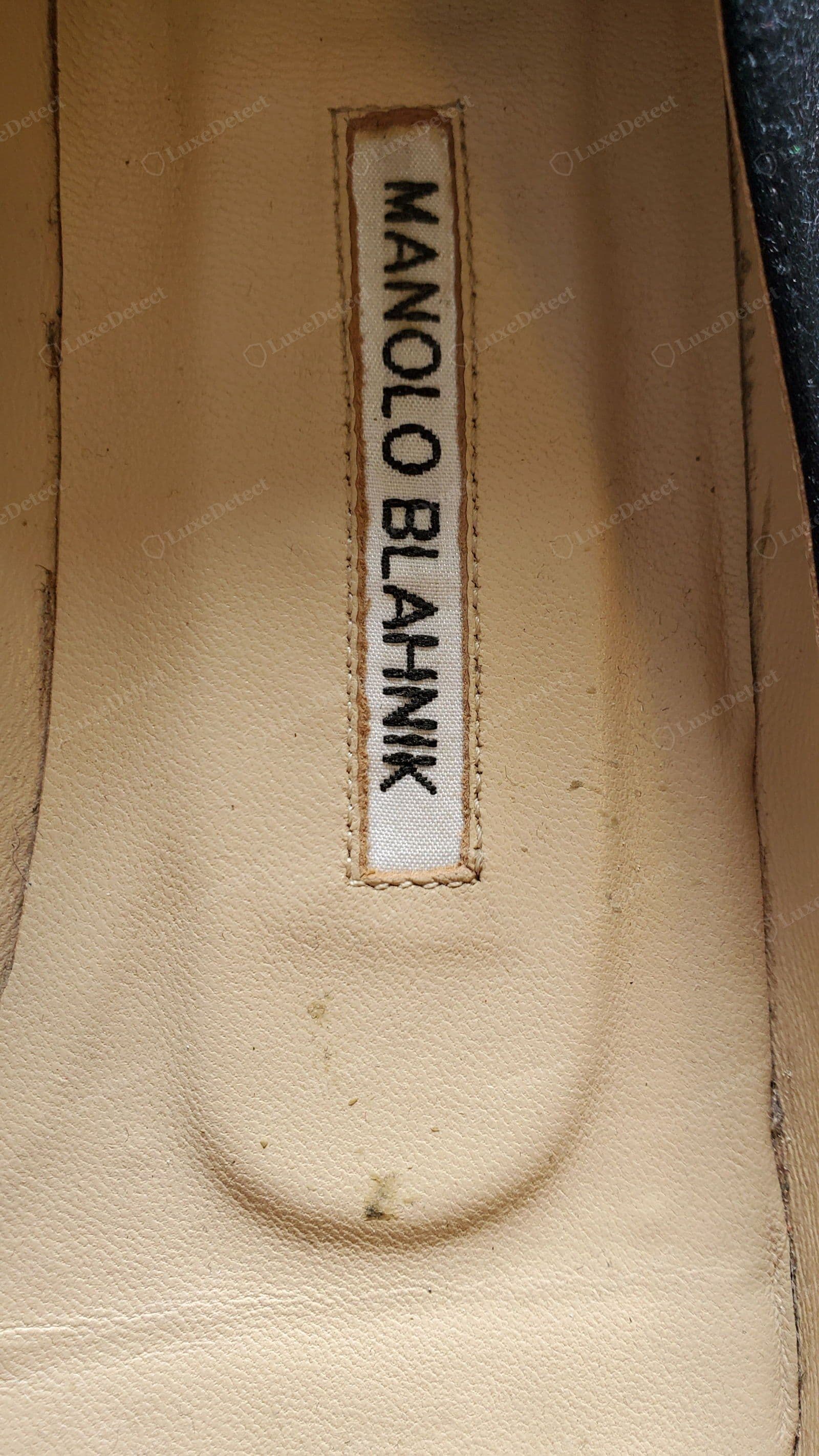 Counterfeit Manolo Blahnik insole — a grubby "MANOLO BLAHNIK" label with uneven, mis-shapen letters and wobbly stitching around a fraying edge