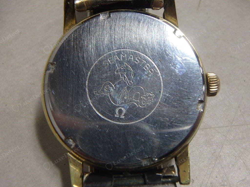 Genuine Omega caseback — engraving and medallion struck cleanly in high relief