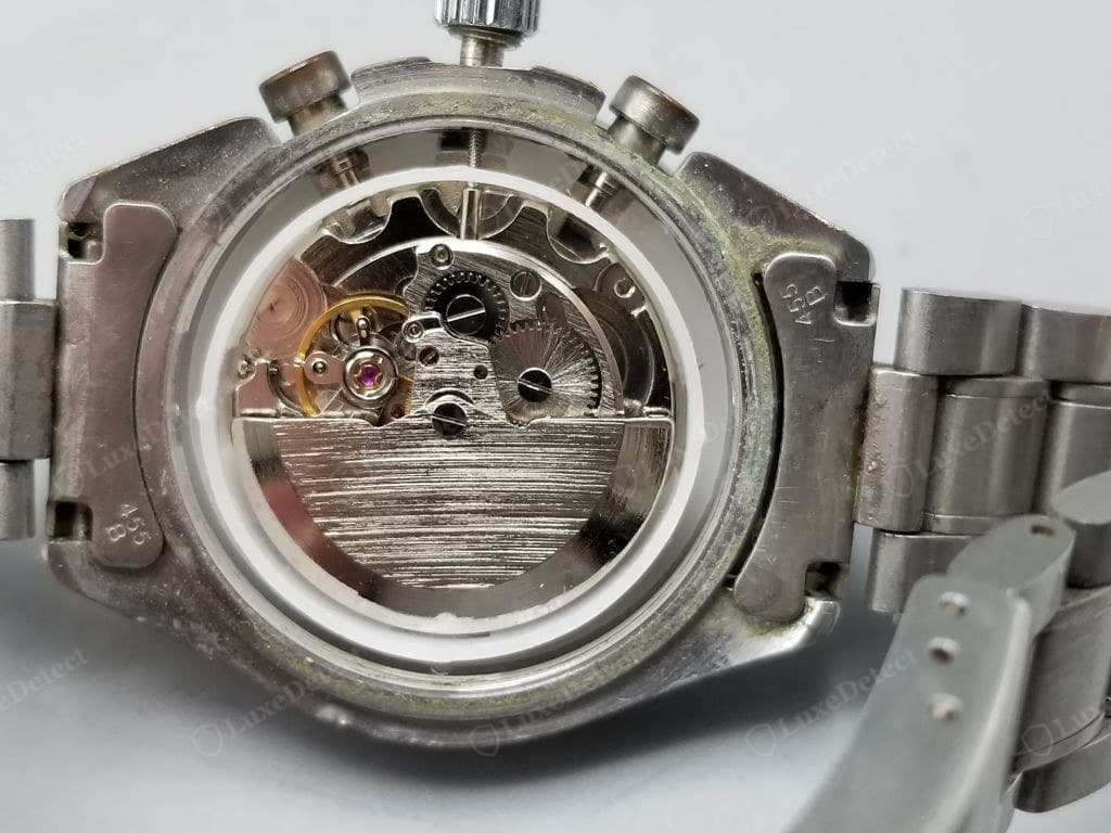 Counterfeit Omega movement — bare or crudely decorated plates, generic components, engraving shallow or absent