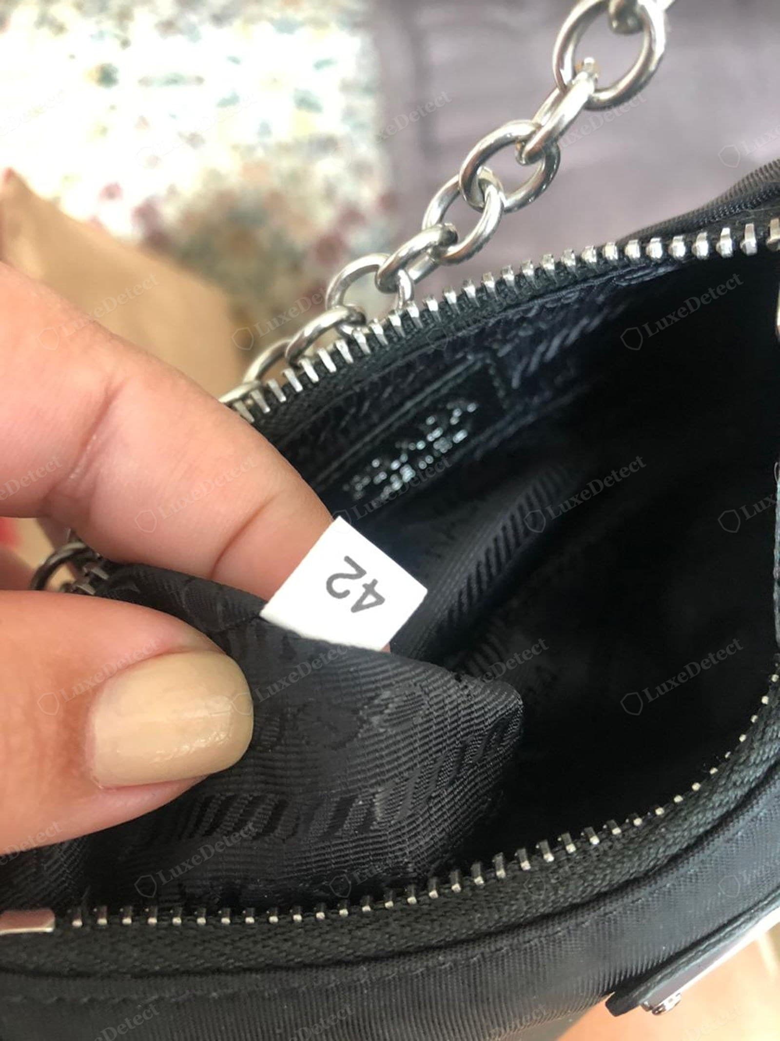 Counterfeit Prada Re-Edition interior — fuzzy stamp, wrong style number, label crooked or raw-edged