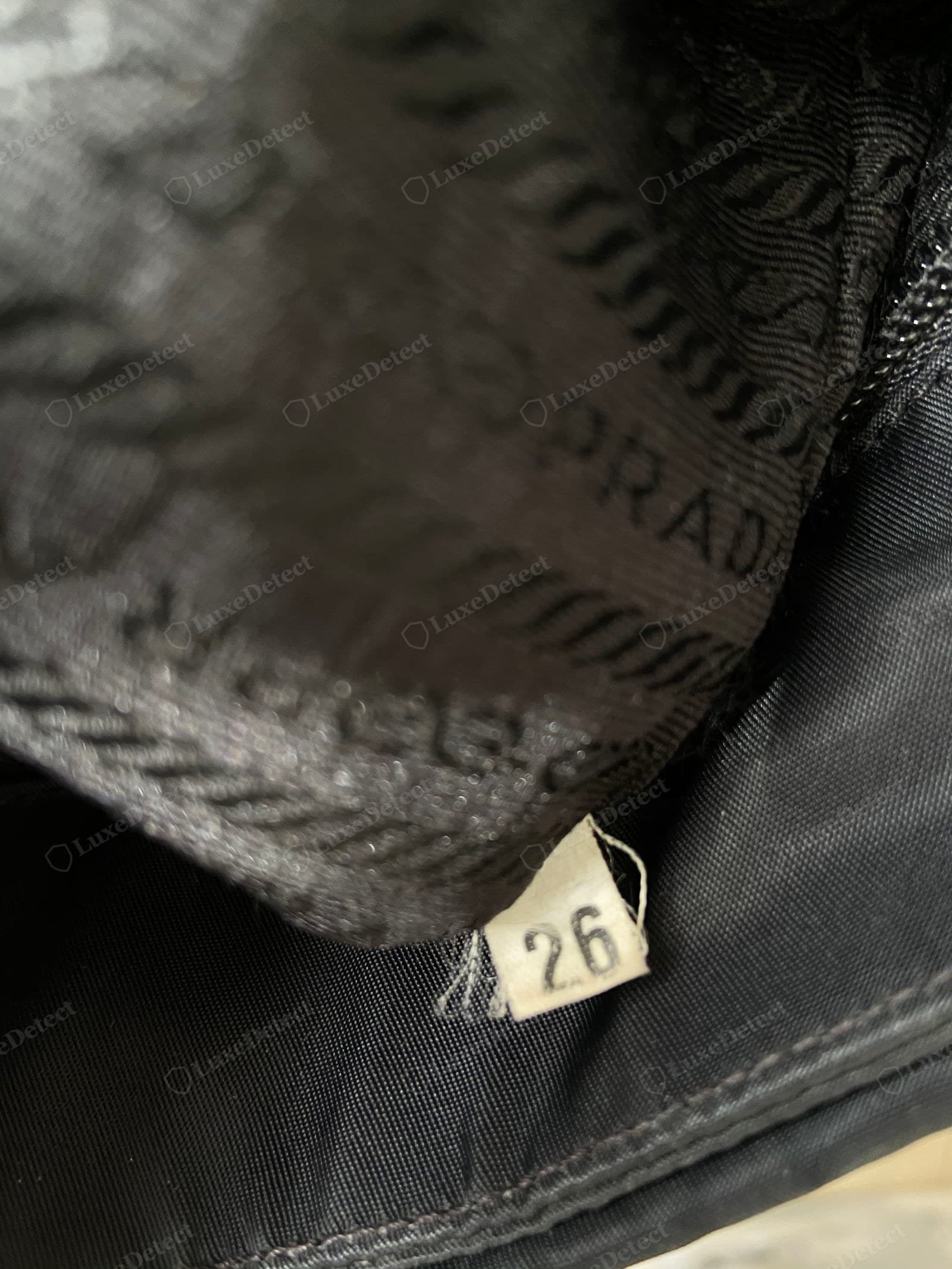 Genuine Prada Re-Edition interior — crisp serif stamp, correct style number, label sewn straight, MADE IN ITALY