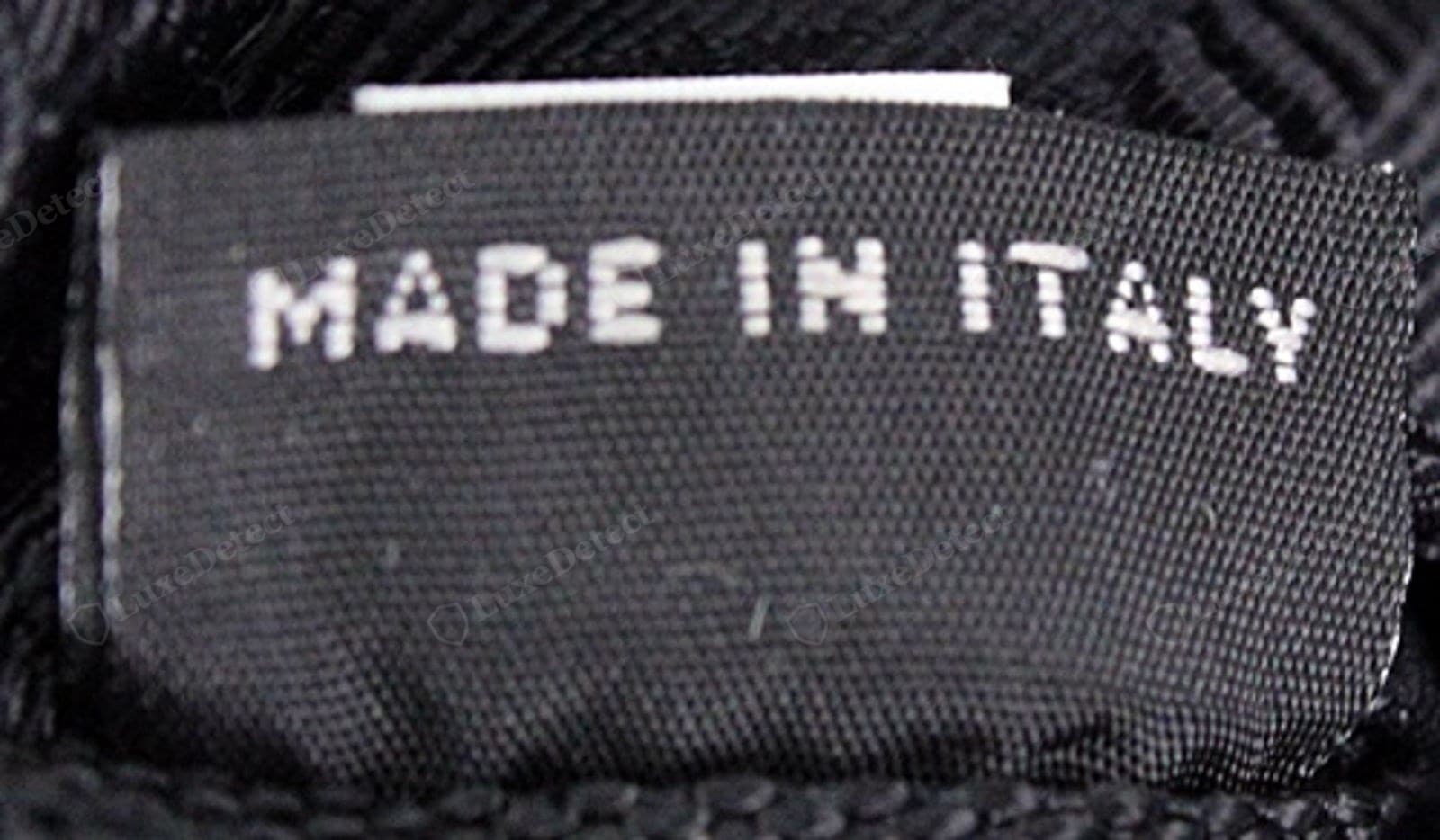 Genuine Prada Re-Edition "MADE IN ITALY" — printed cleanly and correctly spelled on the white care/authenticity label beside the style number and barcode