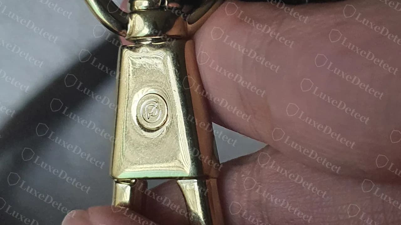 Strap clasp on a genuine medium Pashli: gold lobster clasp with a round engraved logo medallion on its face