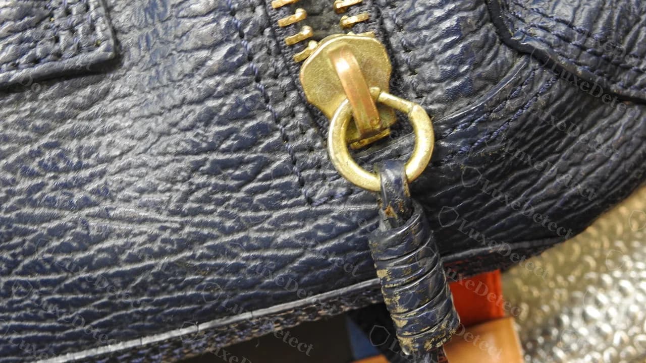 Front zip on a genuine navy Pashli: gold zip ring with a leather pull wrapped and knotted around it