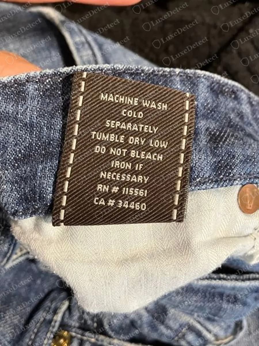 Genuine 7 For All Mankind brown twill care label reading MACHINE WASH COLD SEPARATELY, TUMBLE DRY LOW, DO NOT BLEACH, IRON IF NECESSARY, then RN # 115561 and CA # 34460