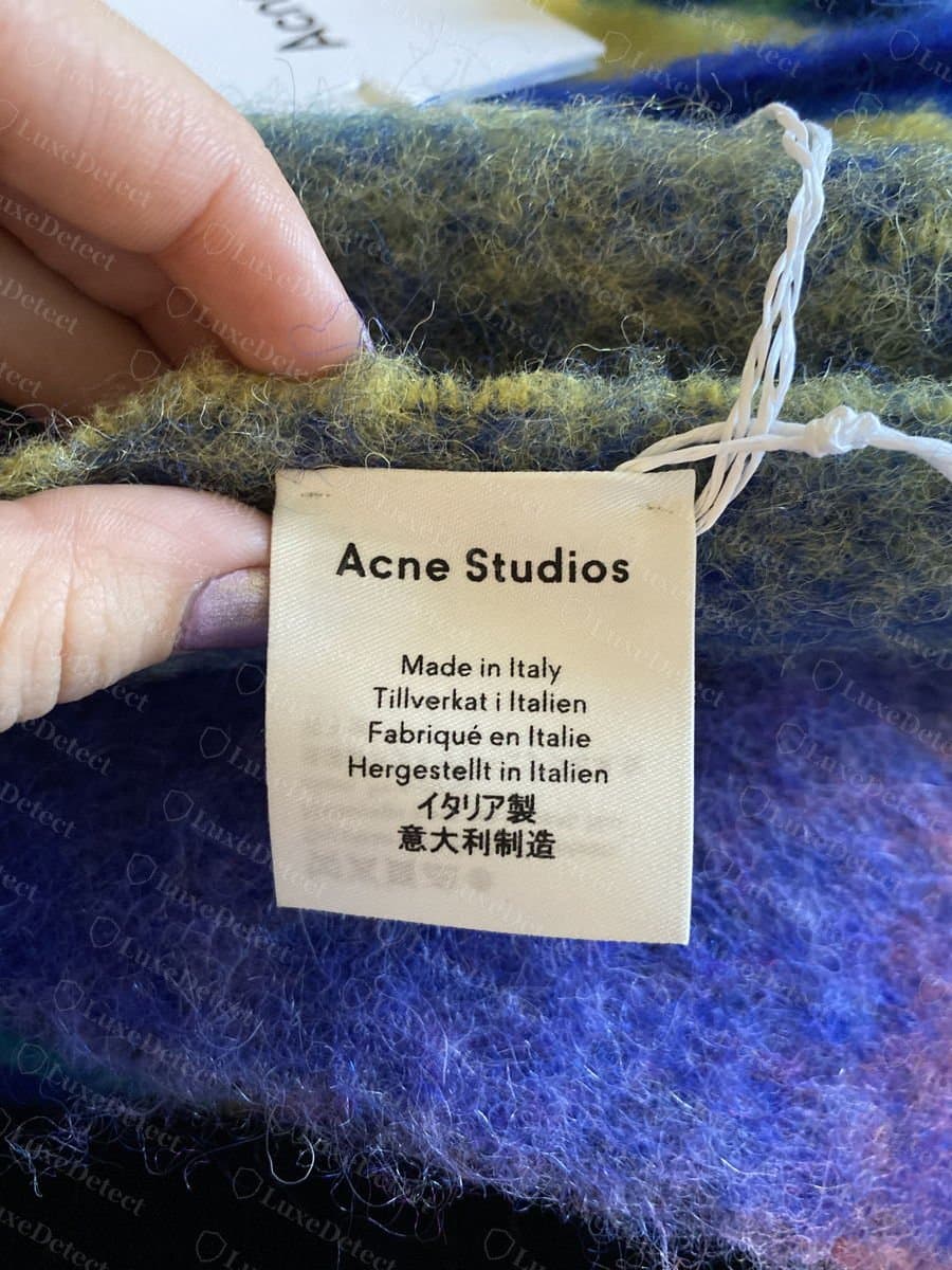 Echt: Pflegeetikett eines Acne-Studios-Schals mit „Made in Italy“ und „Fabriqué en Italie“ in scharfem, richtig geschriebenem, gleichmäßig gesetztem Druck