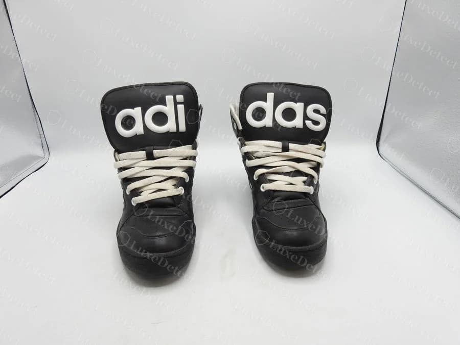 Genuine adidas Jeremy Scott Instinct black leather high-tops with the adidas name split across both tongues as "adi" and "das" in raised white letters