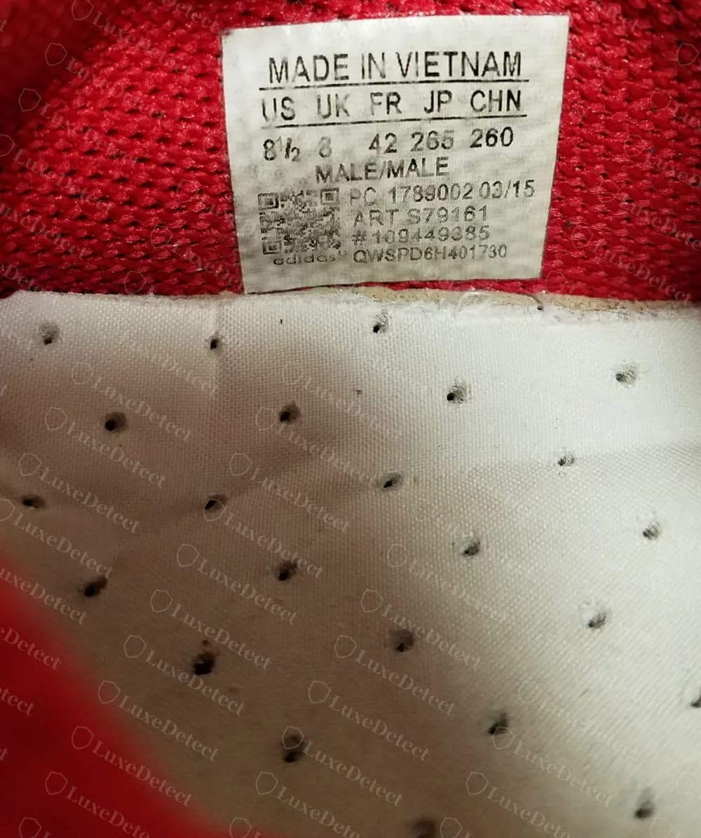 Counterfeit Hu NMD with a plain perforated white insole under a PC 1789002 03/15 label for article S79161