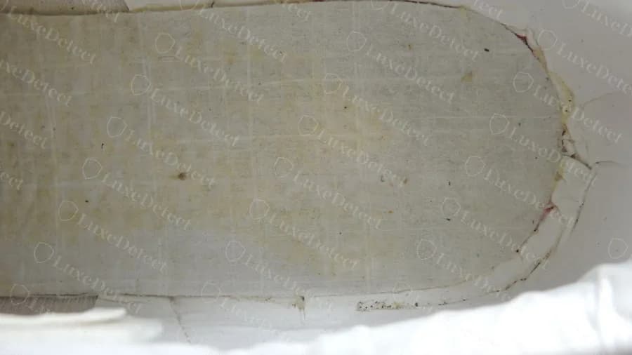 Counterfeit pair with a pale yellowish grid-weave fabric under the insole instead of a stamped board