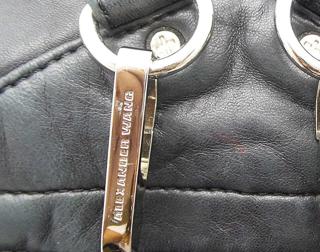 Genuine Alexander Wang hardware — "ALEXANDER WANG" engraved crisply into a nickel snap-hook, with a branded "A" stamped into the adjacent rivet