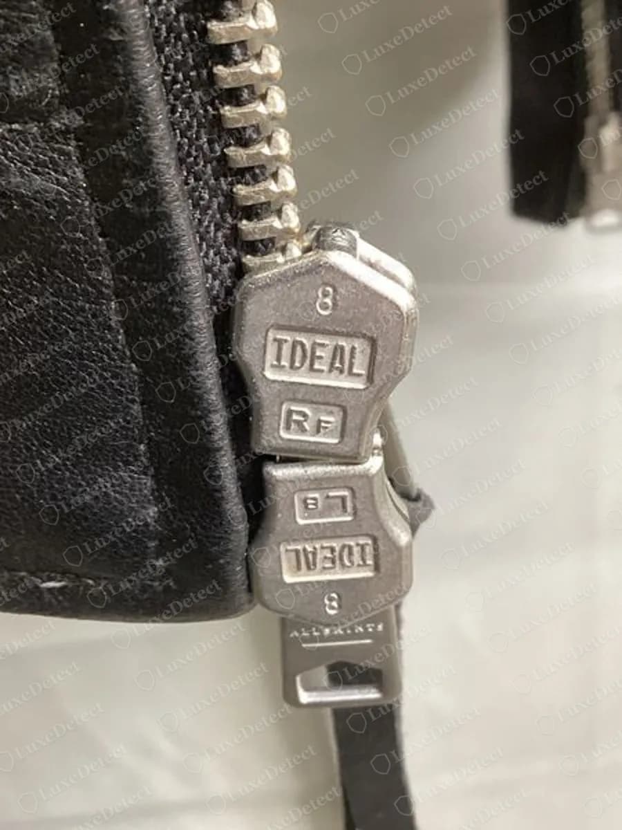 Genuine AllSaints jacket zip puller stamped IDEAL with RF on one slider and LB on the other, a small ALLSAINTS stamp on the pull tab, silver-tone teeth