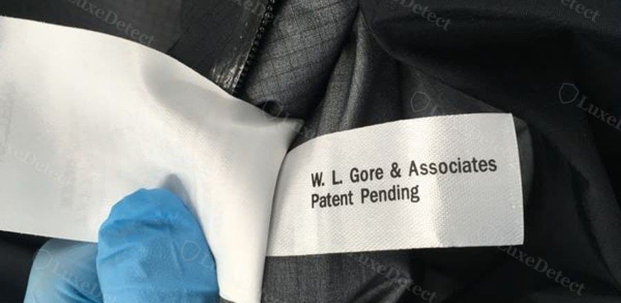 Counterfeit on the same interior seam: a flat printed "W. L. Gore & Associates / Patent Pending" tag instead of licensed GORE-TEX wording.