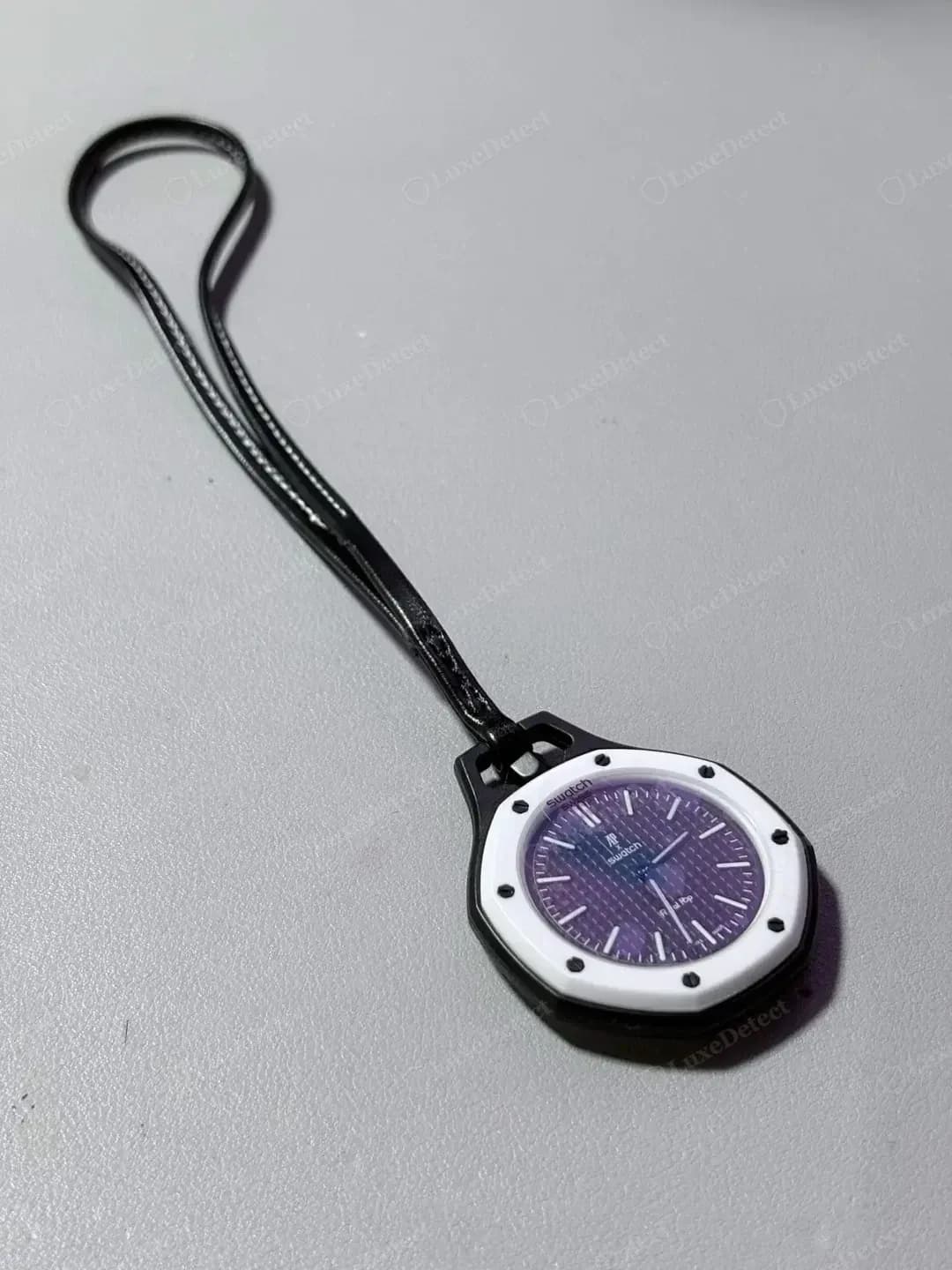 Une Royal Pop contrefaite sur son cordon noir : comparez le boîtier, le support et le cadran avec les montres authentiques ci-dessous.