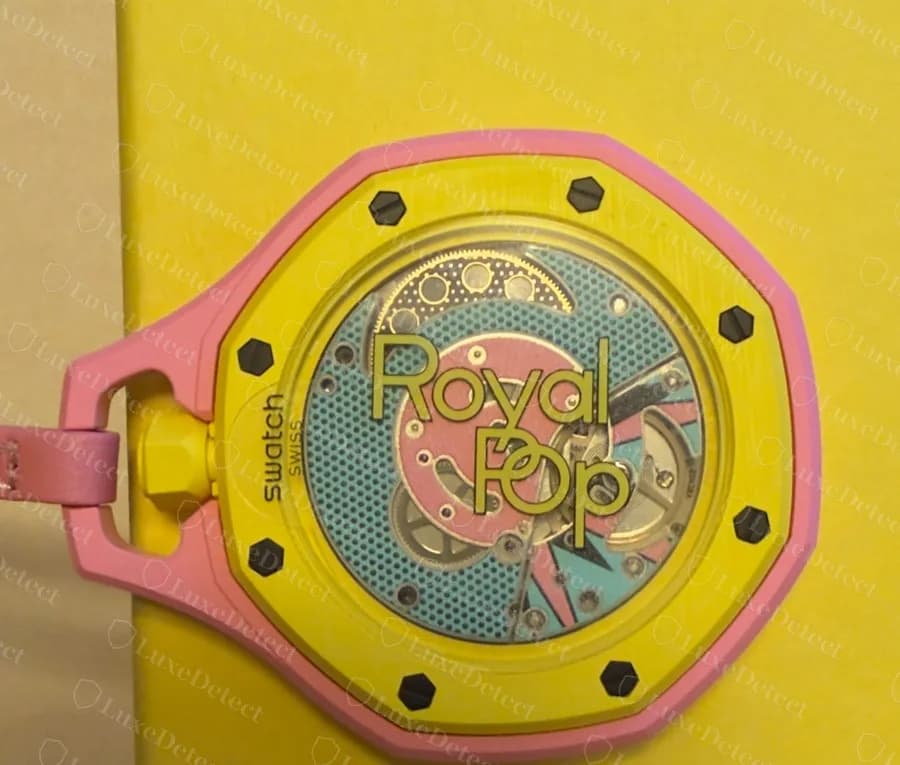 Fondello del Royal Pop originale in stile savonnette: la stampa pop-art e la scritta “Royal Pop” nei colori propri della colorazione sopra il movimento a vista; il piccolo testo “swatch SWISS” sul bordo sinistro si trova sulla pellicola protettiva, che questo proprietario non aveva ancora tolto.