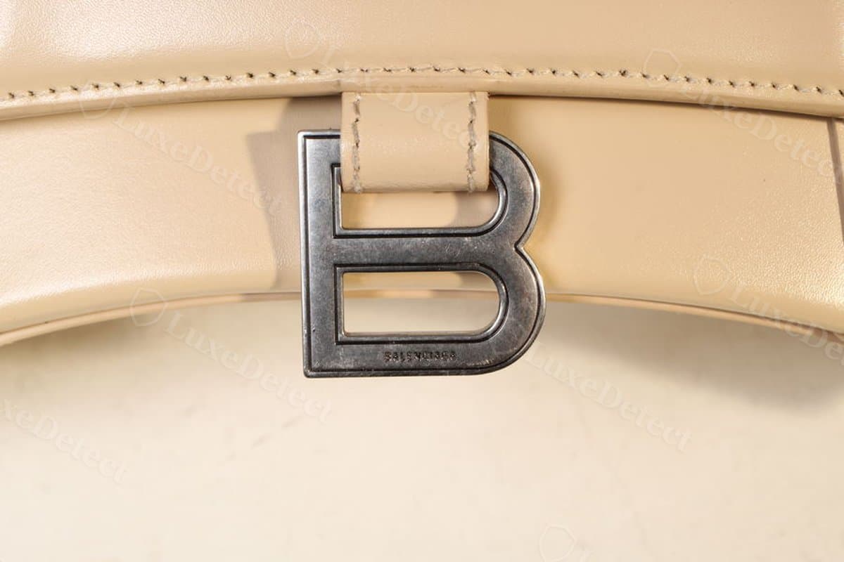 Authentic Hourglass B hardware: satin-finish plate with even bowl proportions, "BALENCIAGA" engraved cleanly beneath the closure