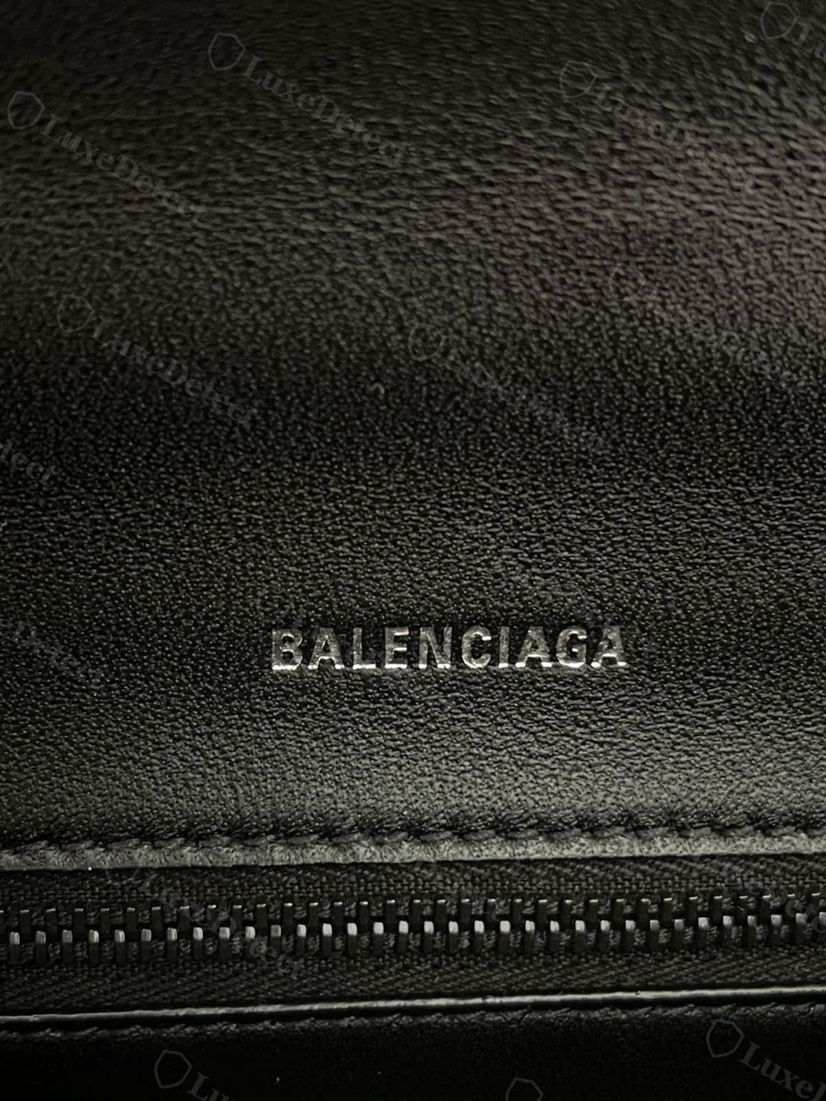 Authentic interior stamp on a black Hourglass: debossed "BALENCIAGA" in silver-tone foil, even letter spacing, leather panel above the zipper