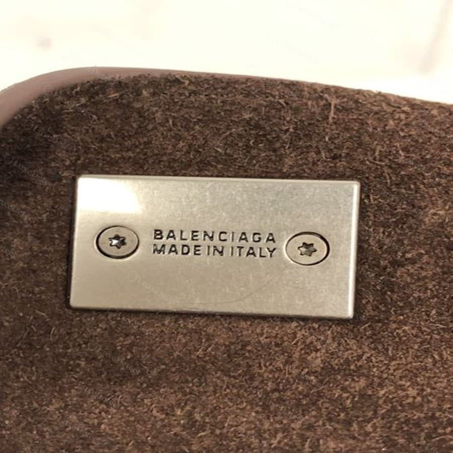 Plaque métallique intérieure d'un sac soumis comme faux : c'est aussi un format légitime de Balenciaga, mais montré ici pour comparer la qualité de l'estampage et de la construction