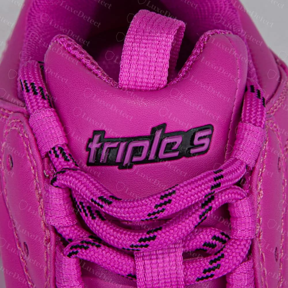 Patch sulla linguetta di una Balenciaga Triple S originale con la scritta triple s, inserita nella pelle magenta della linguetta