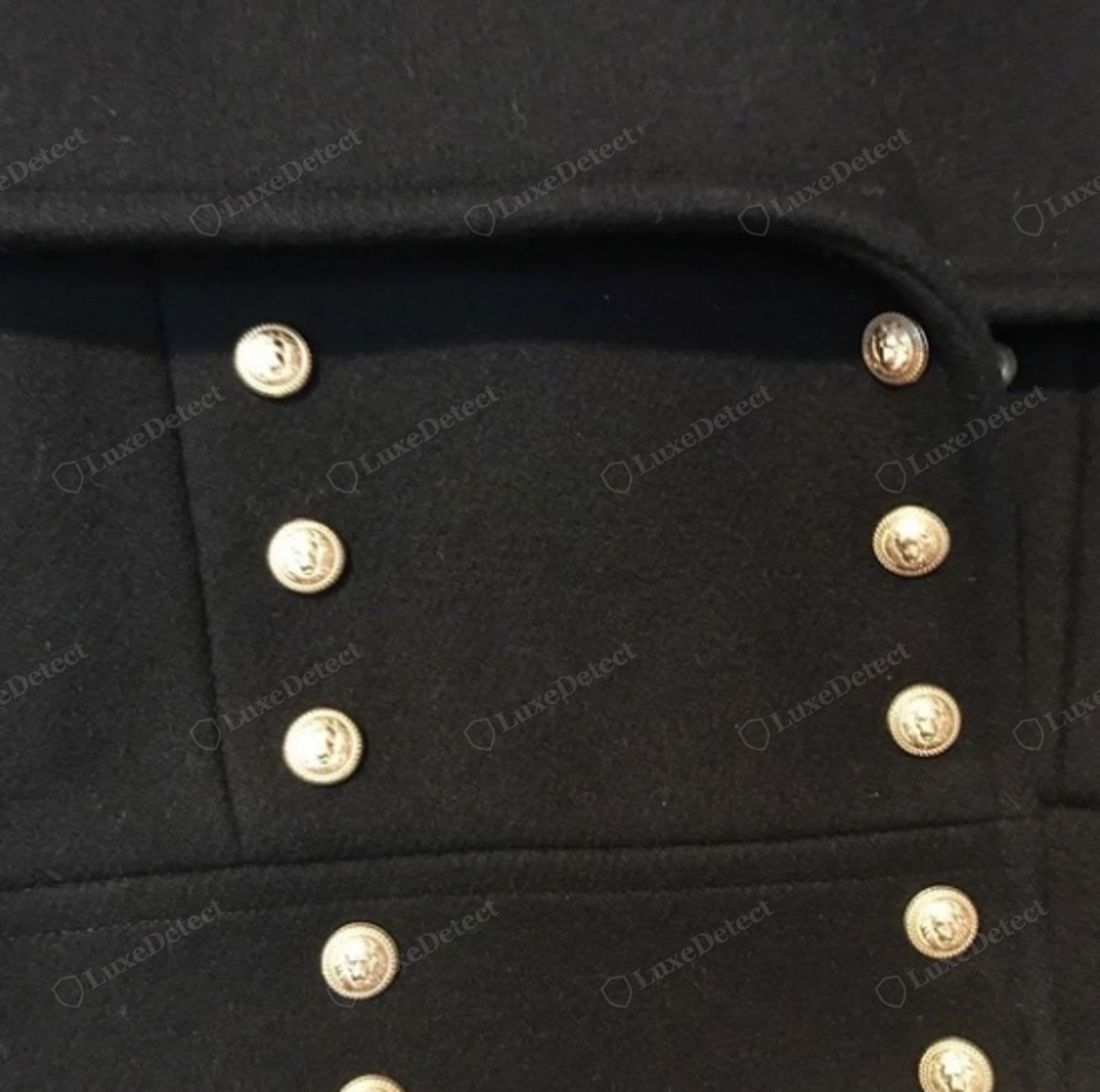 Genuine Balmain buttons — the double-breasted rows of a black military coat set with solid gold lion-head crest buttons, the design crisply raised and evenly plated