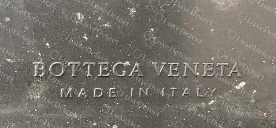 Sola externa de uma Lug original: BOTTEGA VENETA com MADE IN ITALY abaixo, moldados na borracha preta.