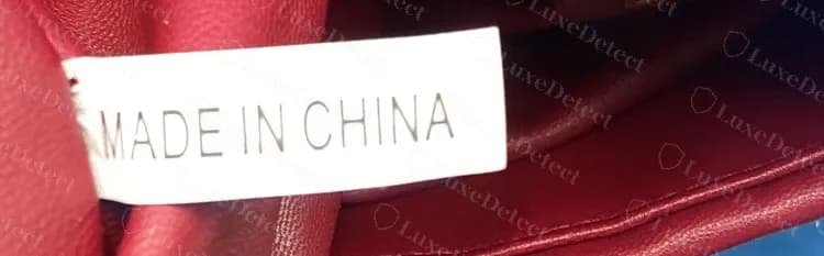 Bolsa falsificada com uma etiqueta branca simples impressa "MADE IN CHINA" dentro do forro