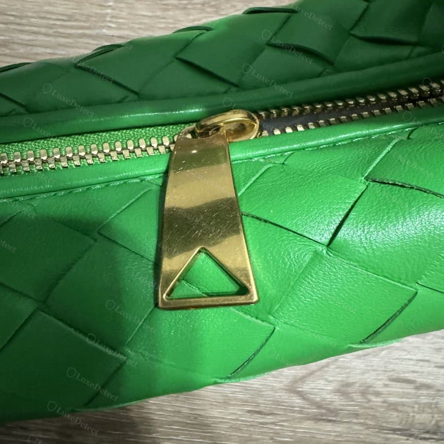 Zipper pull from a bag submitted as a fake — a flat, stamped tab, shown for construction comparison