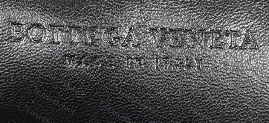 Counterfeit woven Pouch heat stamp: deeper and more sharply cut, but close enough to the genuine layout that the stamp alone would not identify it