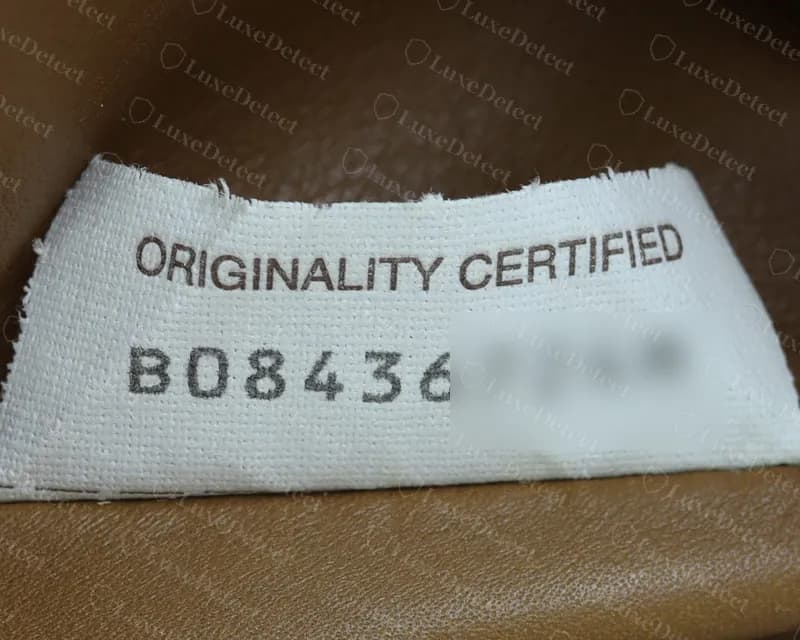 Genuine Originality Certified tag from a Pouch: brown heading, dark grey code in an even typeface (we have blurred the last characters of the code)