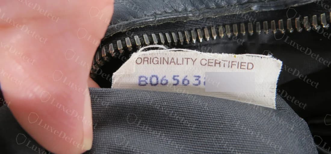 Etichetta Originality Certified originale con il codice stampato in inchiostro blu violaceo, la fine del codice sfocata