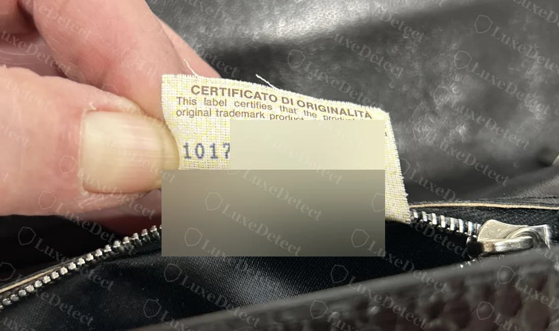 Etichetta Certificato di Originalita più vecchia, originale, sollevata all’interno di una borsa, con la maggior parte dei numeri sfocata