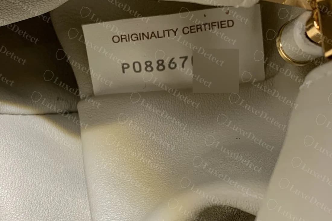 Counterfeit Pouch with an Originality Certified tag in the same layout as a genuine one, the end of the code blurred