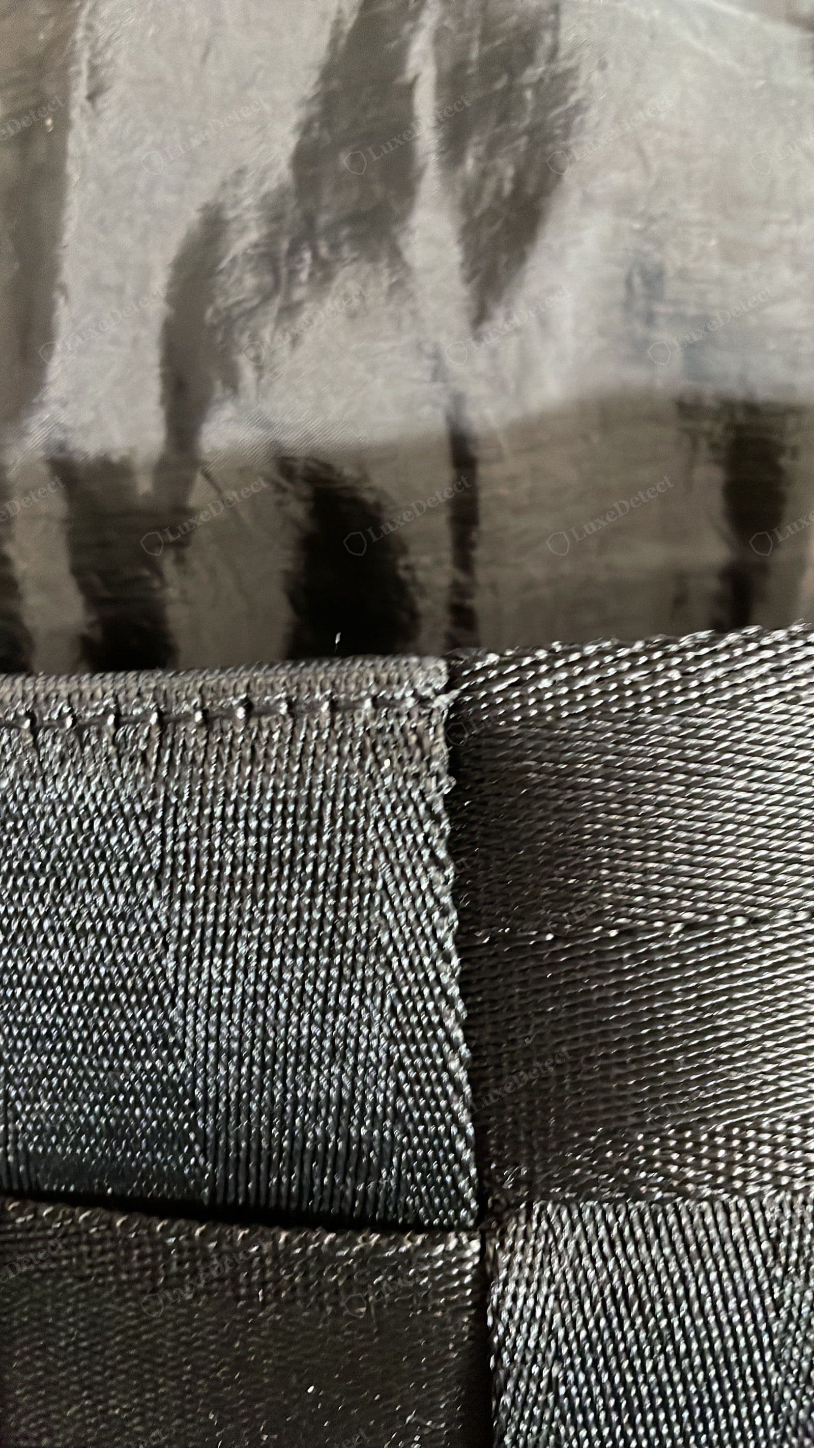 Counterfeit Cassette interior: a cheap crinkled synthetic lining and a textile grosgrain webbing strap where the genuine bag uses smooth leather