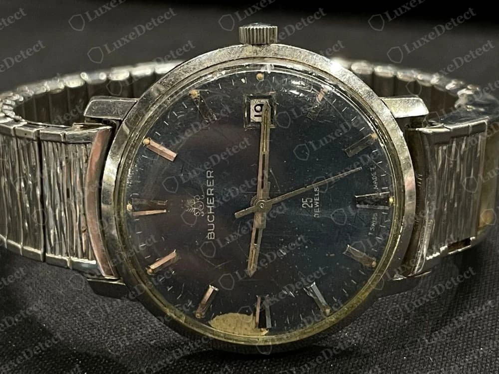 Genuine vintage Bucherer automatic with a dark blue dial, a small crest printed above the BUCHERER name, a 25 JEWELS line, a date window and a flexible textured bracelet