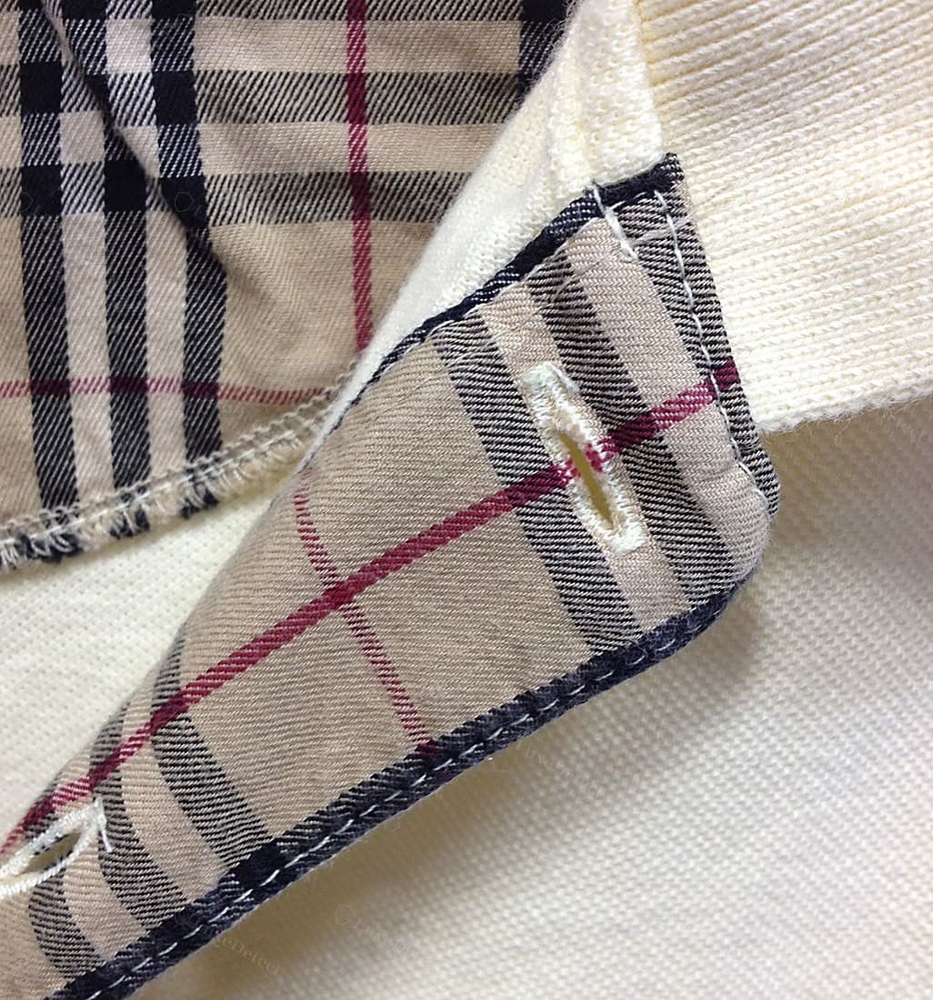 Col et patte de boutonnage Burberry contrefaits : le revers à carreaux aux bords cotonneux et effilochés au-delà du surfilage, boutonnières coupées grossièrement avec du fil lâche, surpiqûre qui dévie