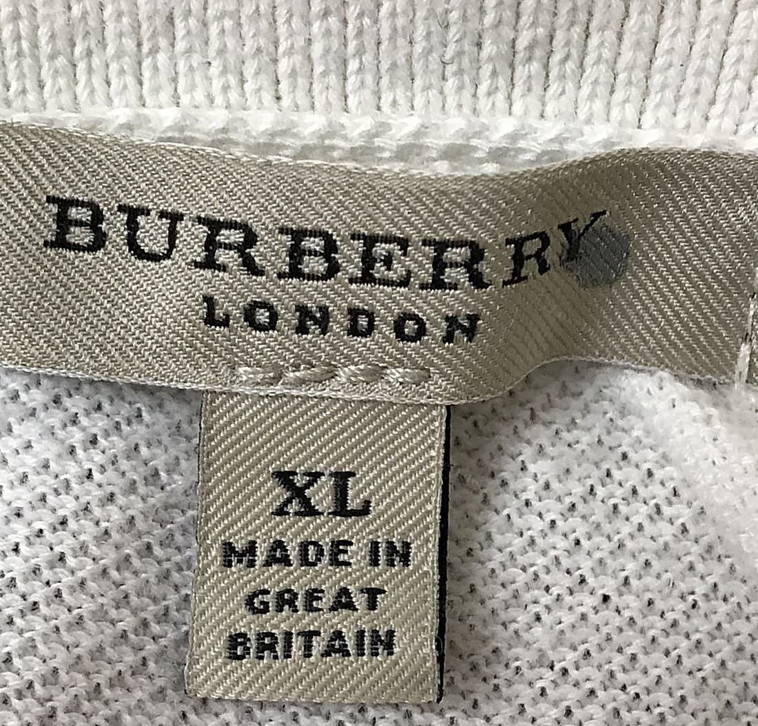 Etiqueta del cuello Burberry original: "BURBERRY LONDON" de tejido denso con letras nítidas de bordes limpios, cosida plana y a escuadra, con una pestaña prolija "XL / MADE IN GREAT BRITAIN" debajo, de impresión nítida
