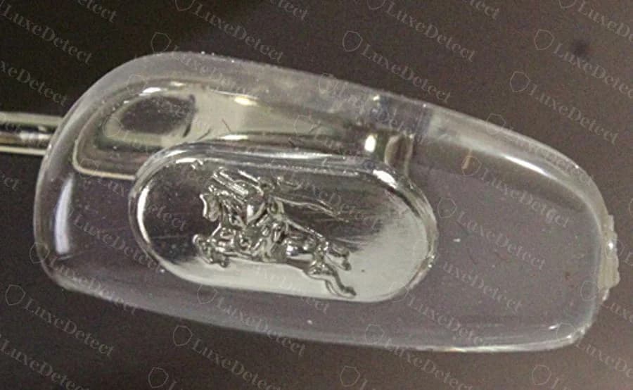 Authentic equestrian knight logo molded into a clear acetate nosepad, showing distinguishable leg and banner detail.