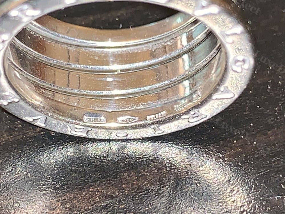 Authentic interior stamps: a clear 750 fineness mark, assay symbol, and brand mark cut into the innermost band.