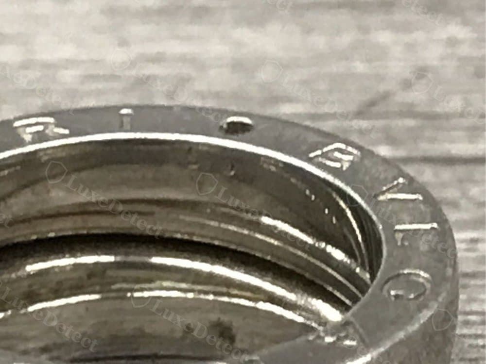 A counterfeit ring with a rougher, unevenly finished band where the spiral loops meet.
